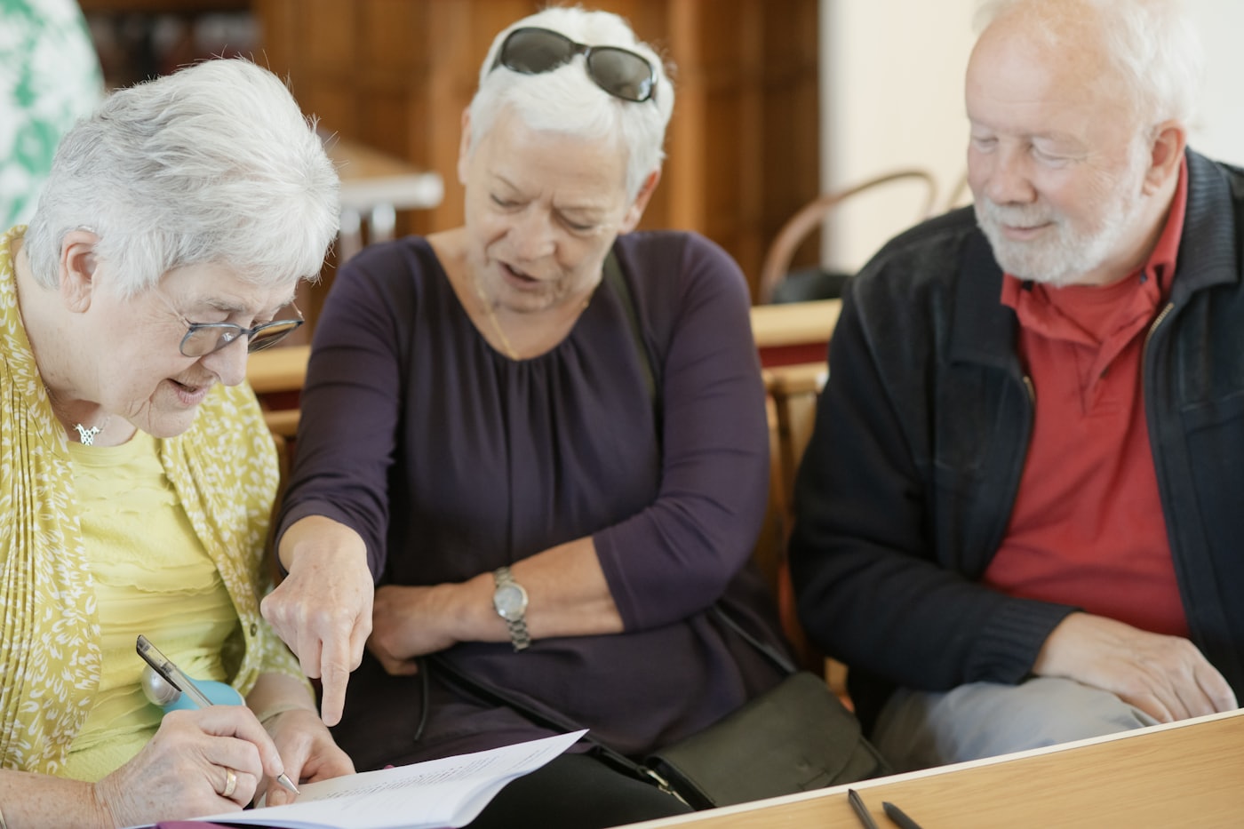 Three club officers sitting together, reading a document.